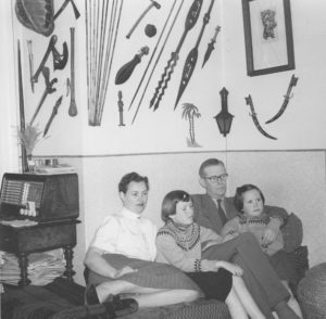 Far, mor og de to piger opstillet til foto, formentlig omkring 1951. Våbensamlingen har jeg et par stykker af på min væg, min søster har andre. Trøjerne - ens! - har mor strikket. 